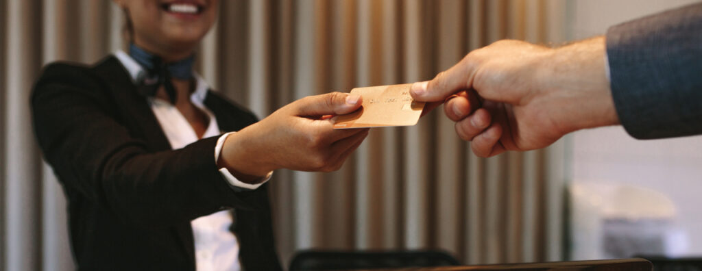 Hotel receptionist processing a guest’s credit card payment—leveraging Eventions credit card analytics to streamline reconciliation and financial accuracy.